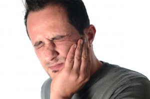 Man experiencing the denture-related problem of oral pain