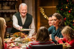 A happy grandfather waits for a serving of holiday turkey